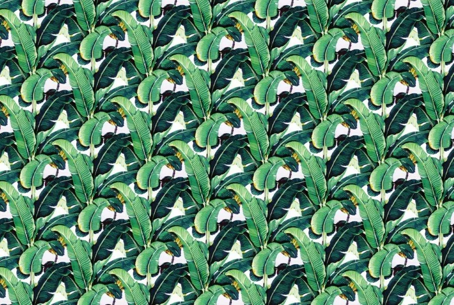 Repeating pattern of overlapping green and dark banana leaves with cream negative space on white background