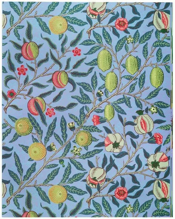 Repeating botanical wallpaper pattern with red pomegranates, yellow fruits, green leaves, and pink flowers on a light blue background.