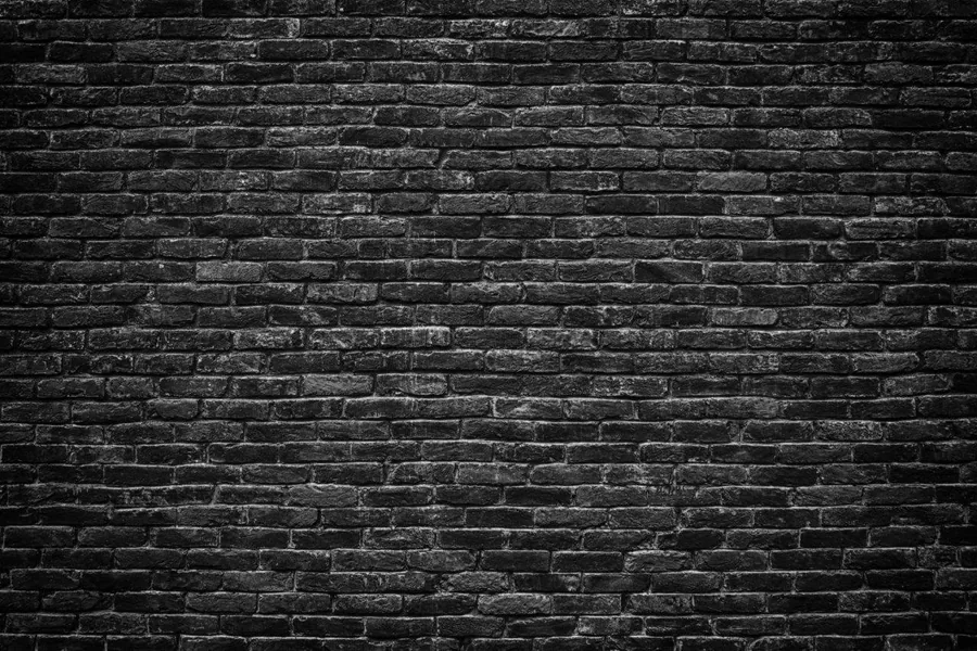 Dark charcoal brick wall texture with grey mortar lines and realistic weathered surface