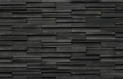 Staggered charcoal and grey brick tiles with varied surface textures creating a 3D wall effect