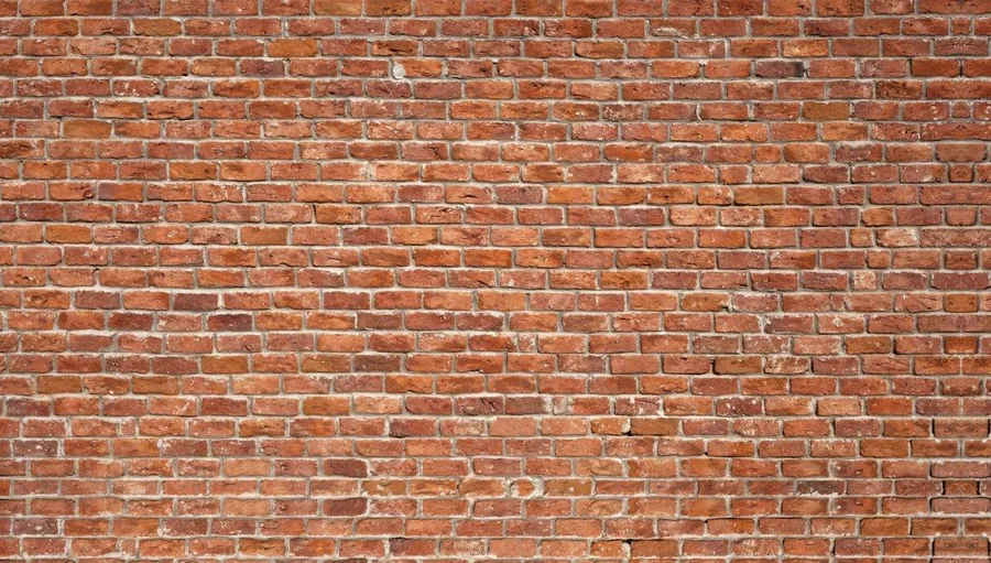 Seamless terracotta brick wall texture with grey mortar joints and natural weathering.
