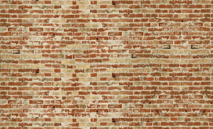 Repeating pattern of rustic red and cream clay bricks with gray mortar joints