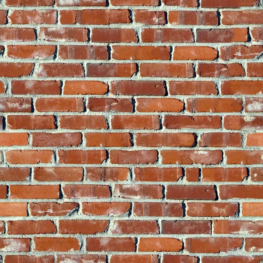 Close-up of traditional red and orange brick wall with white grout joints in running bond pattern