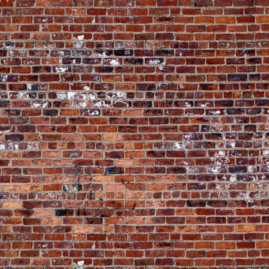 Close-up of aged red and brown brick wall with white mortar joints and weathered surface texture