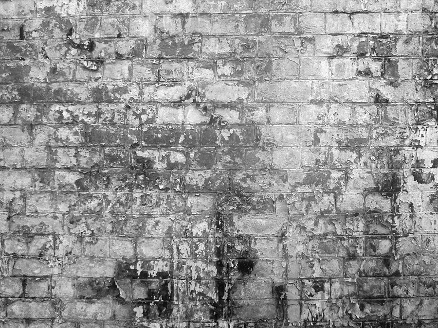 Monochrome distressed brick wall texture with varied weathering and concrete-like finish.