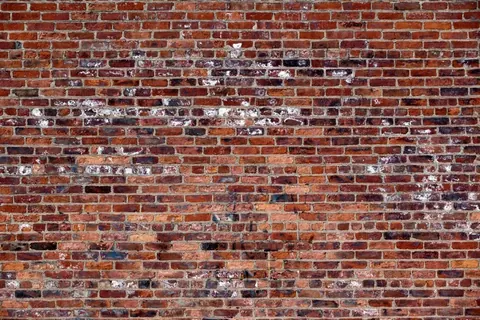 Distressed red brick wall texture with faded white paint and natural wear patterns