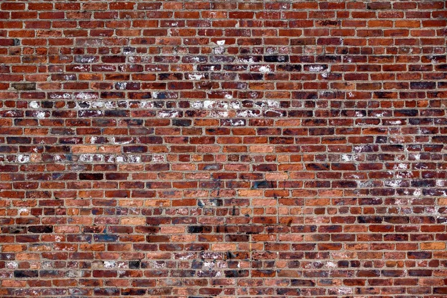 Distressed red brick wall texture with faded white paint and natural wear patterns