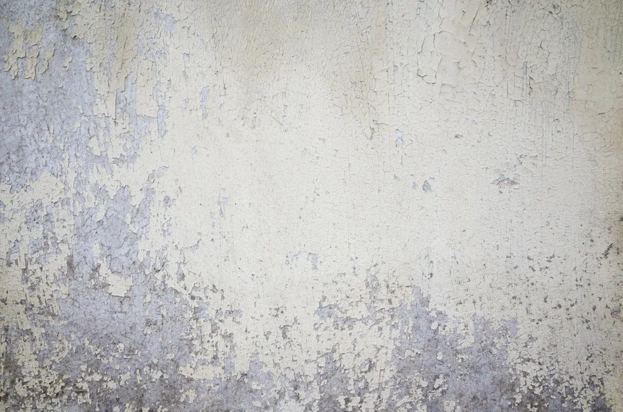 Weathered concrete texture with peeling plaster in soft grey and cream tones