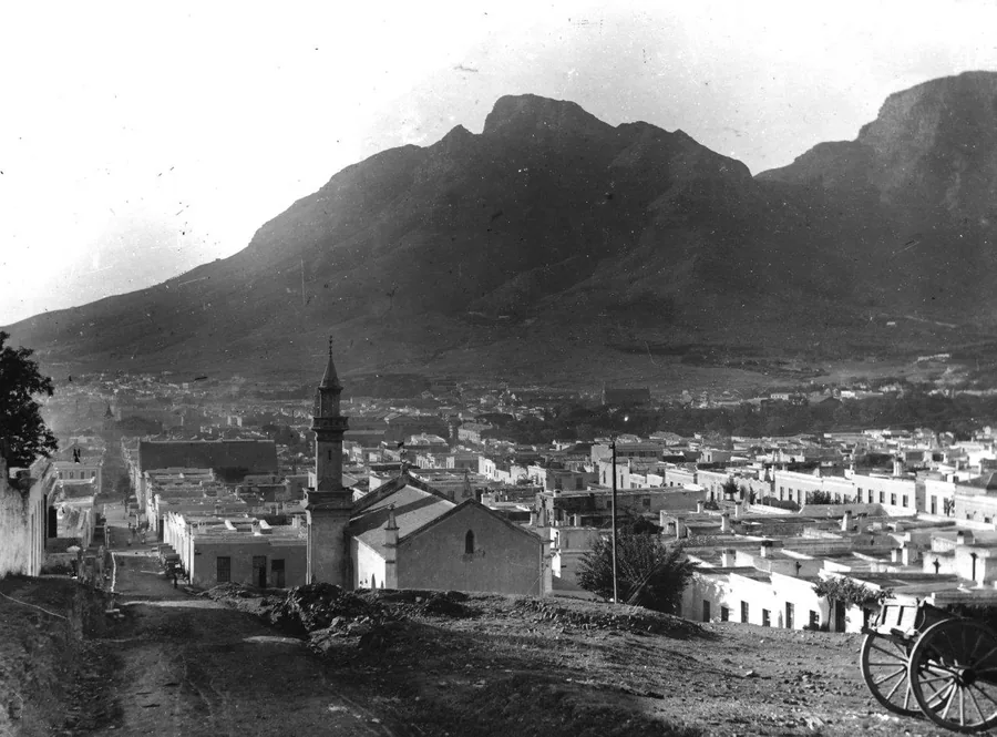 Black and white vintage photograph of Table Mountain dominating Cape Town's skyline with colonial architecture below