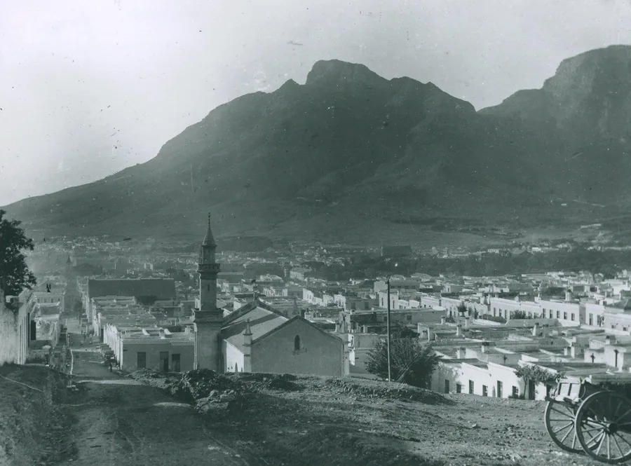 Vintage black and white photograph of Table Mountain overlooking Cape Town's white-washed buildings and church spire