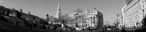 Black and white panoramic street scene of London with historic buildings, church spire, and city architecture
