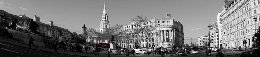 Black and white panoramic street scene of London with historic buildings, church spire, and city architecture