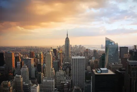 Golden hour view of Manhattan skyline with Empire State Building and Hudson River at sunset