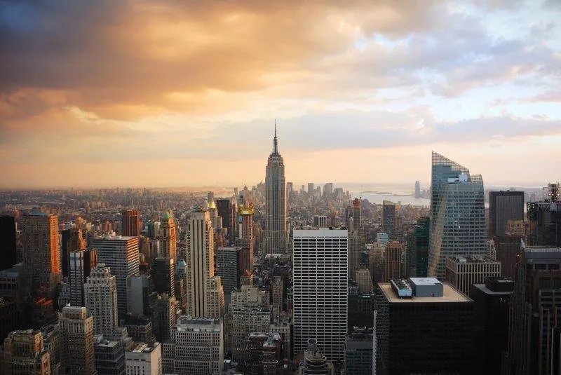 Golden hour view of Manhattan skyline with Empire State Building and Hudson River at sunset