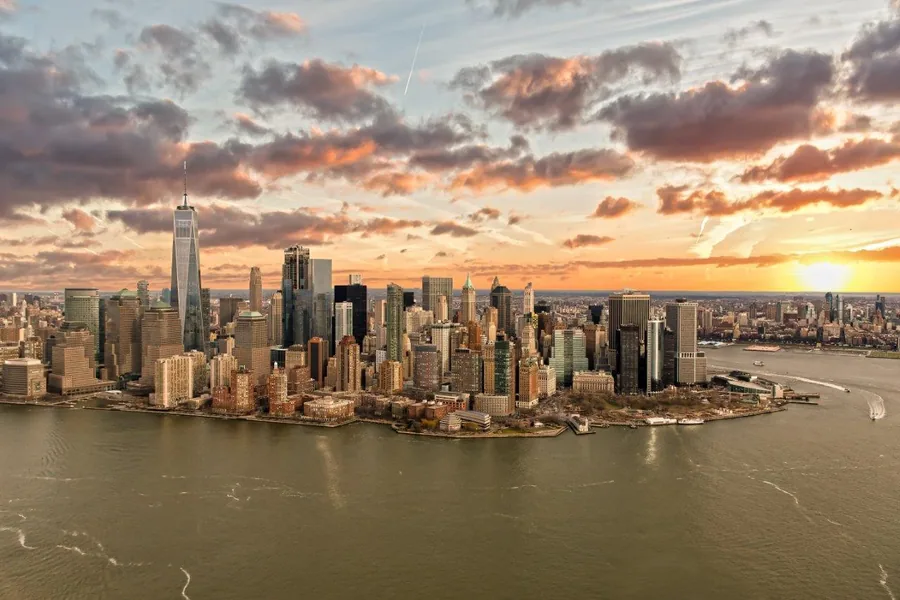 Aerial view of Manhattan skyline at sunset with golden clouds and waterfront