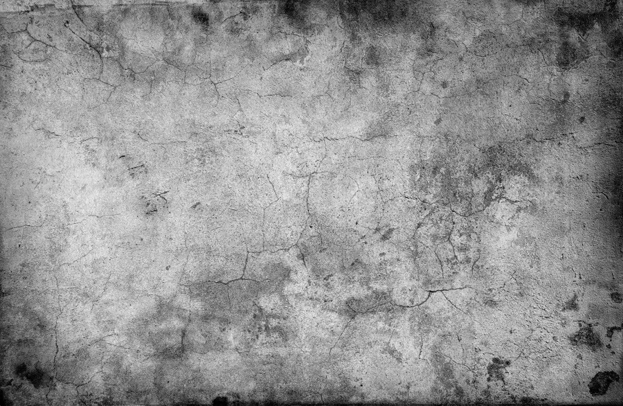 Grayscale concrete texture with fine cracks, stains, and weathered surface detail.