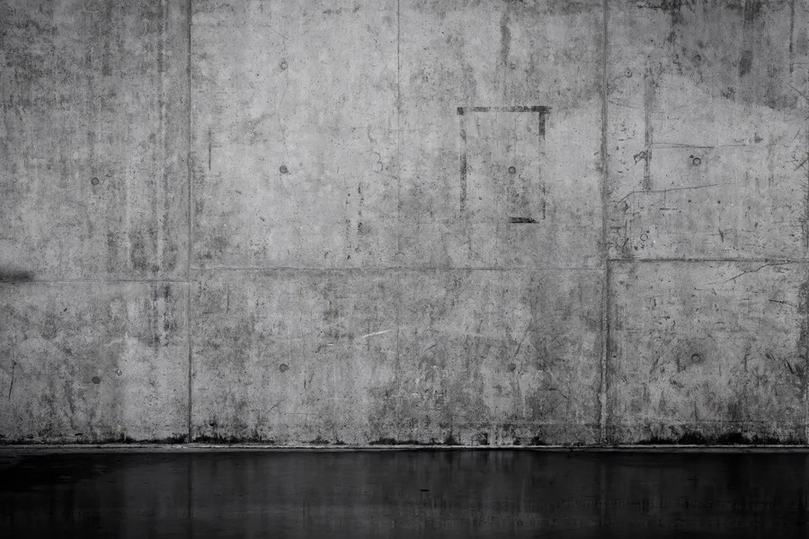 Aged concrete wall panels with visible seams, stains, and weathered surface texture.