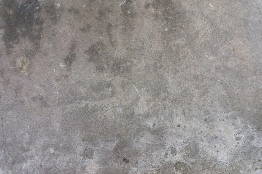 Close-up of weathered concrete surface with dust, stains, and natural texture variations