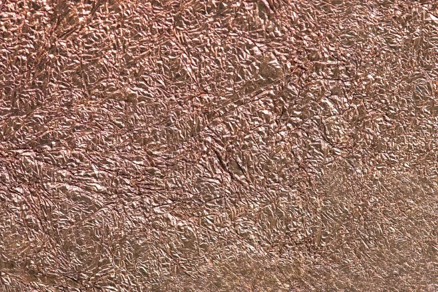 Crinkled copper metallic texture with warm bronze highlights and dimensional wrinkled surface