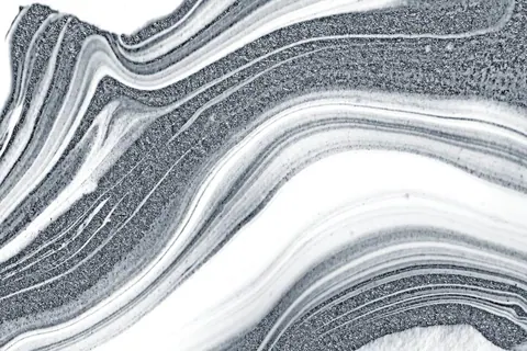 Abstract liquid metal texture with flowing waves in gray, silver, and white tones.