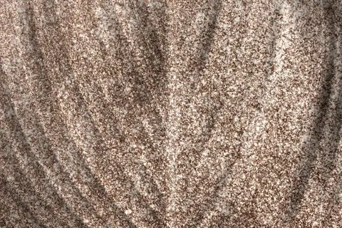 Close-up of speckled metallic wallpaper texture in taupe and cream with vertical wave pattern