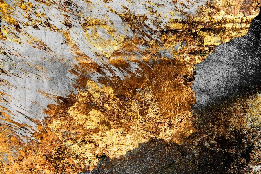 Weathered gold and bronze metallic texture with rust-like patina on grey background