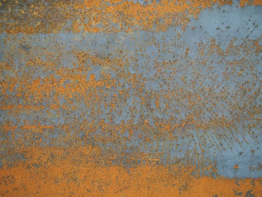 Weathered metal surface with orange rust patina and blue-grey oxidation texture