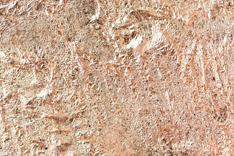 Weathered rust and patina texture with warm tan, cream, and rust-brown tones on a metallic surface
