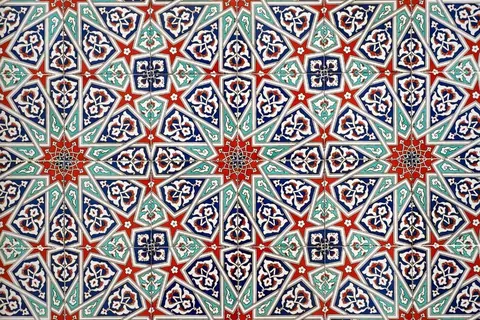 Repeating geometric mosaic tile pattern with red stars and ornate navy and turquoise floral medallions