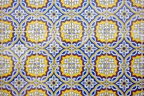 Repeating Portuguese tile pattern with blue, gold, and white ornamental geometric designs and central floral motifs