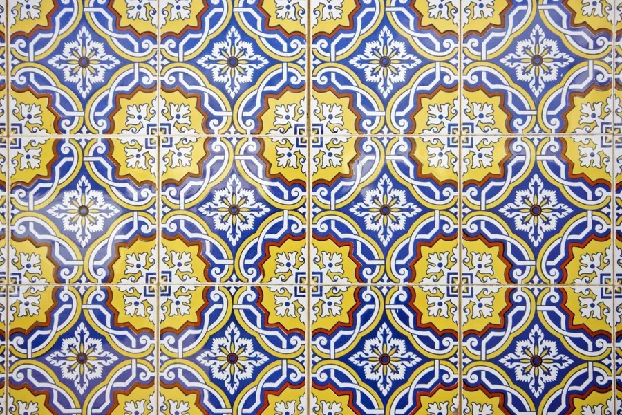 Repeating Portuguese tile pattern with blue, gold, and white ornamental geometric designs and central floral motifs