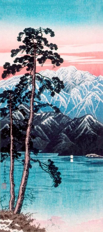 Silhouetted pine tree beside turquoise lake with snow-capped mountains at sunset in pink and blue tones.