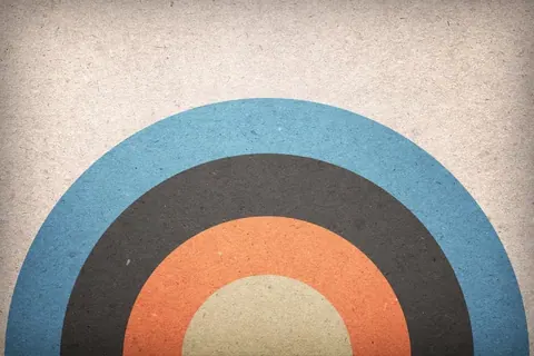Concentric circles in blue, charcoal, orange, and cream on textured background
