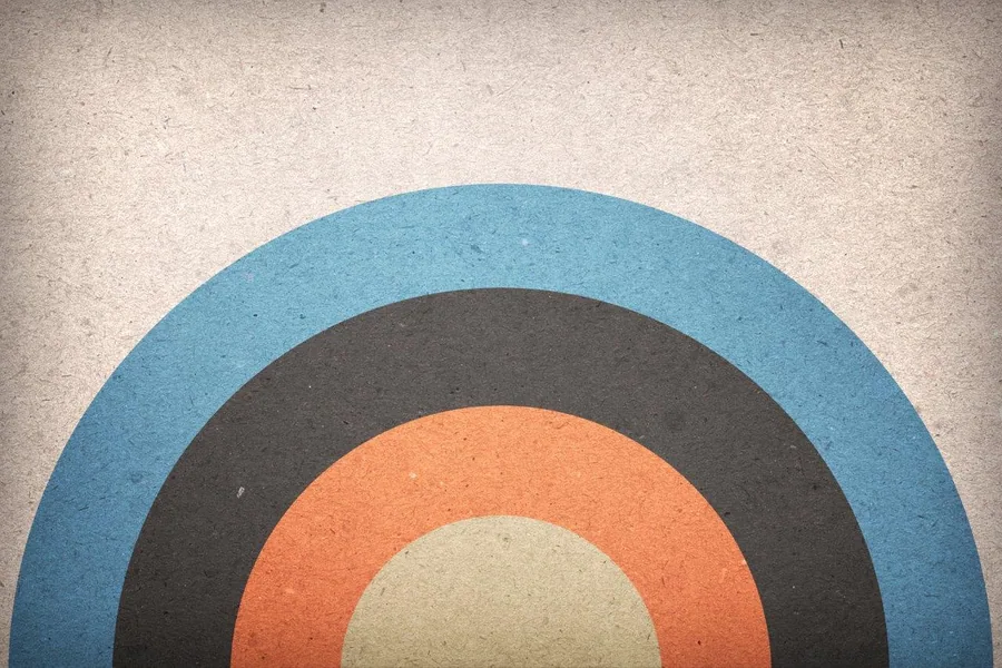 Concentric circles in blue, charcoal, orange, and cream on textured background