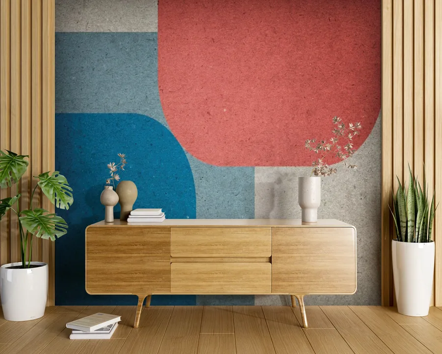 Abstract mural with geometric shapes in blue, coral, and grey tones on a textured wall