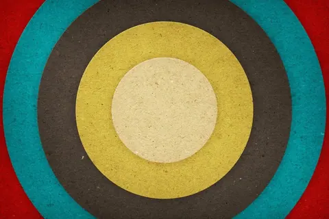 Concentric circles in cream, yellow, charcoal, teal, and red creating a retro bullseye pattern.