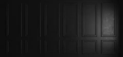 Dark charcoal panelled wall texture with dimensional rectangular sections creating architectural depth