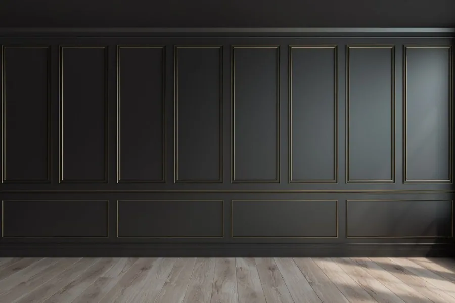 Dark charcoal wall panelling with bronze-trimmed rectangular frames and light wood flooring