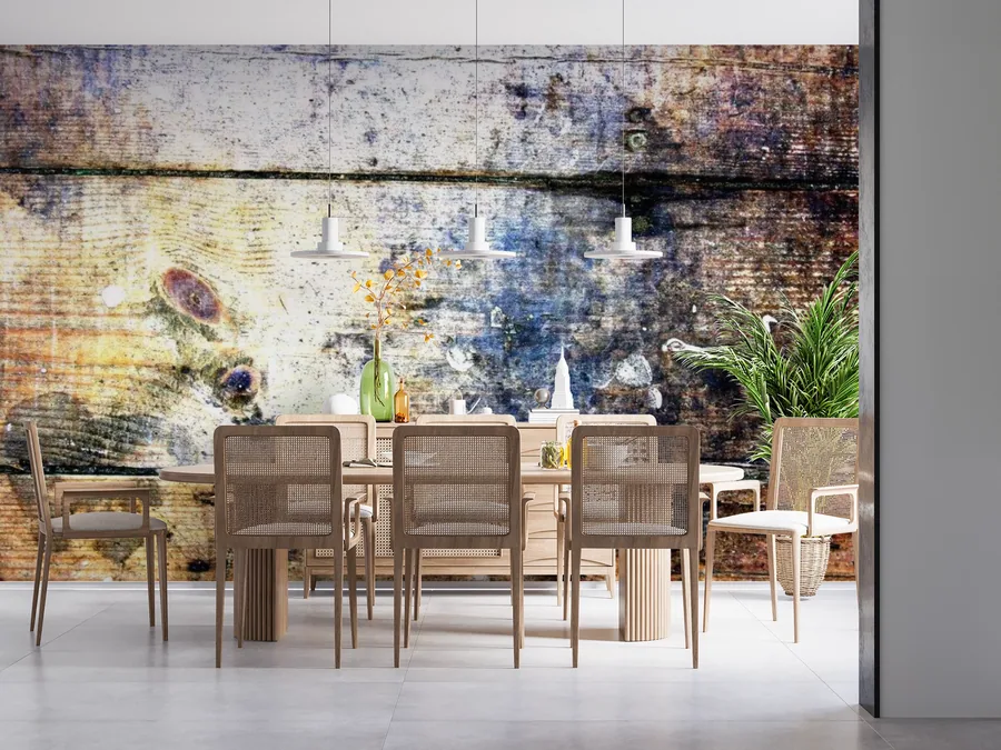 Distressed wooden wall with blue and yellow paint splashes, botanical elements, and minimalist pendant lights in dining setting.