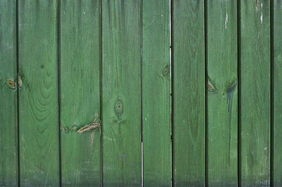 Vertical green wooden planks with natural grain texture and knots