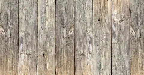 Close-up of weathered wooden planks with natural grain patterns and knots in grey and brown tones.